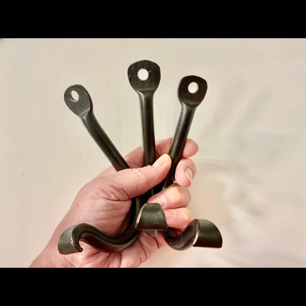 FOUR hand‎ forged iron hooks.